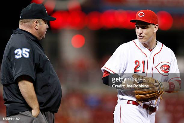 Todd Frazier of the Cincinnati Reds talks with third base umpire Wally Bell during the game against the Philadelphia Phillies at Great American Ball...
