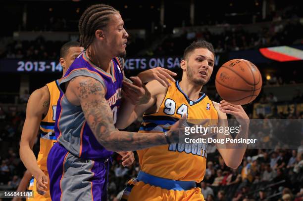 Michael Beasley of the Phoenix Suns and Evan Fournier of the Denver Nuggets battle for control of a loose ball at the Pepsi Center on April 17, 2013...