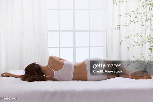 young lady lying on bed - acostado de lado fotografías e imágenes de stock