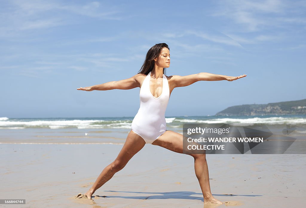 Woman doing yoga on Australian beach, Warrior Pose
