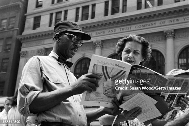 People look through the premiere issue of Sports Illustrated magazine on a Manhattan sidewalk, New York, New York, August 16, 1954.