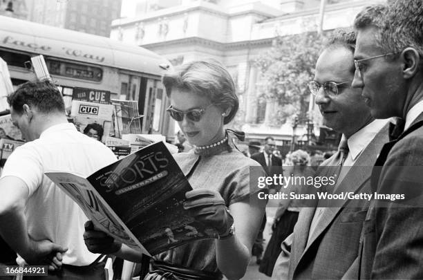 People look through the premiere issue of Sports Illustrated magazine on a Manhattan sidewalk, New York, New York, August 16, 1954.