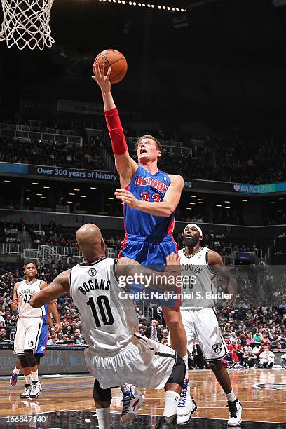 Jonas Jerebko of the Detroit Pistons shoots against Keith Bogans of the Brooklyn Nets on April 17, 2013 at the Barclays Center in the Brooklyn...