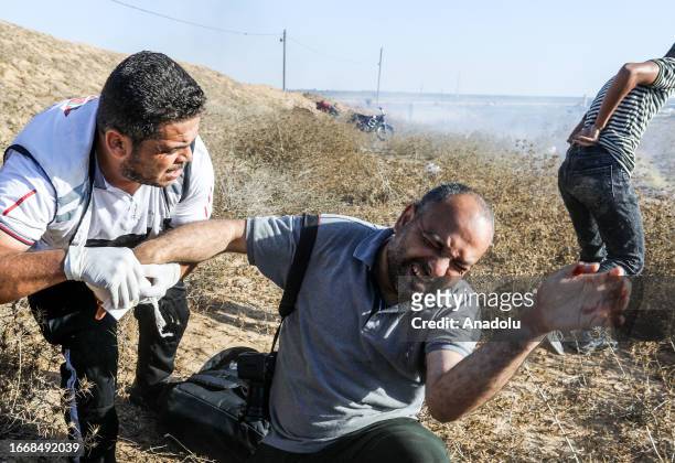 Medics help Ashraf Amra, photojournalist of Anadolu Agency , as he is shot in his hand while on duty as a result of the intervention of Israeli...