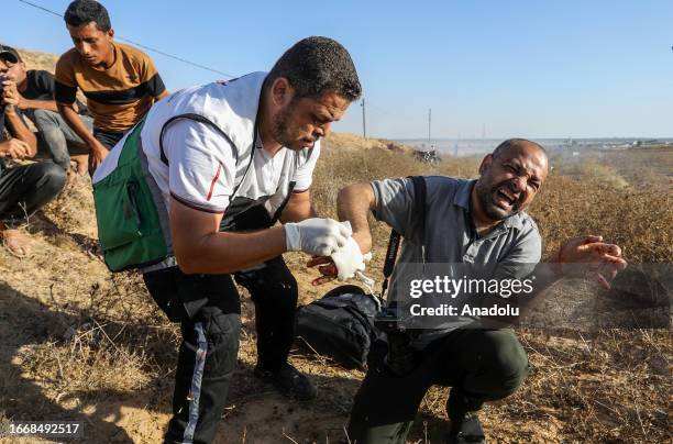 Medics help Ashraf Amra, photojournalist of Anadolu Agency , as he is shot in his hand while on duty as a result of the intervention of Israeli...