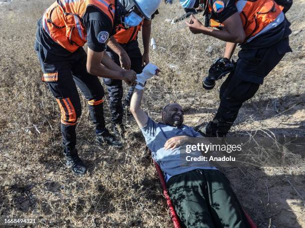 Medics help Ashraf Amra, photojournalist of Anadolu Agency , as he is shot in his hand while on duty as a result of the intervention of Israeli...