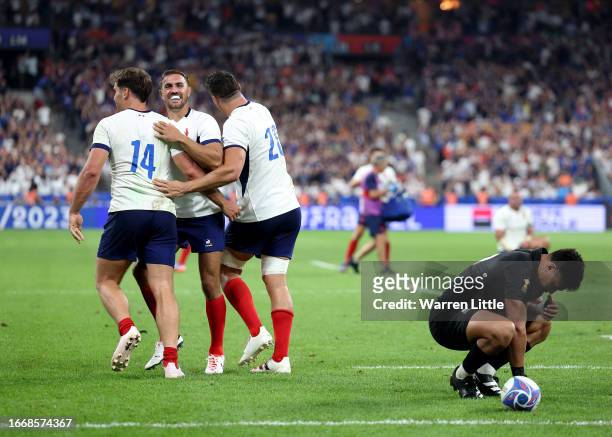 Melvyn Jaminet, Damian Penaud and Paul Boudehent of France celebrate their side's second try as Richie Mo'unga of New Zealand looks dejected during...