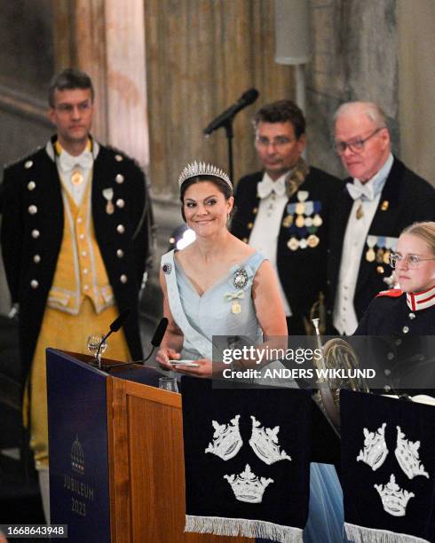 Sweden's Crown Princess Victoria addresses her father the King during the jubilee banquet in the Rikssalen at Stockholm Palace on the occasion of the...