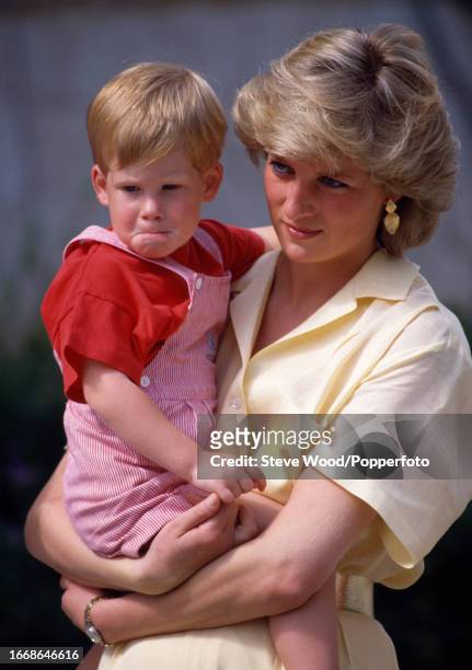 Princess Diana with her son Prince Harry outside Marivent Palace in Palma, Majorca on 10th August, 1987. Princess Diana is wearing a pale yellow...