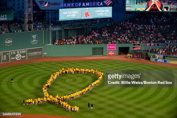 Guests are introduced in a ribbon formation during a pre-game ceremony in recognition of Childhood Cancer Awareness before a game between the Boston...