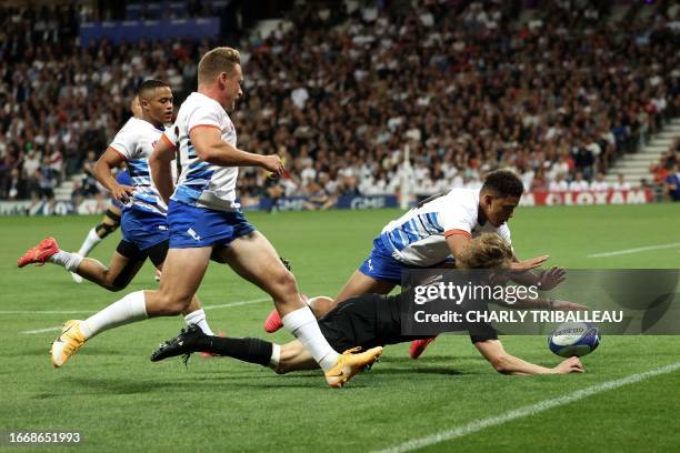 New Zealand's fly-half Damian McKenzie dives for the ball with Namibia's wing Gerswin Mouton during the France 2023 Rugby World Cup Pool A match...