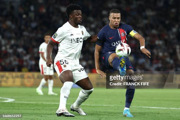 Nice's Burundian defender Youssouf Ndayishimiye and Paris Saint-Germain's French forward Kylian Mbappe fight for the ball during the French L1...
