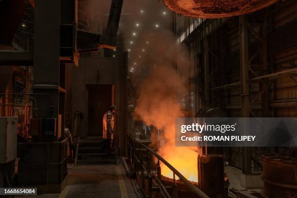 An employee wearing a protective gear works in a continuous steel casting department at the ArcelorMittal steel plant, in Kryvyi Rig, southern...