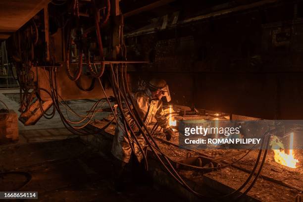 An employee wearing a protective gear works in a continuous steel casting department at the ArcelorMittal steel plant, in Kryvyi Rig, southern...