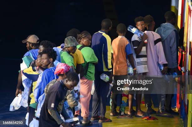 Migrants are seen entering in the ferry outside of the hotspot as nearly 7,000 irregular migrants arrive in Lampedusa island of Italy on September...