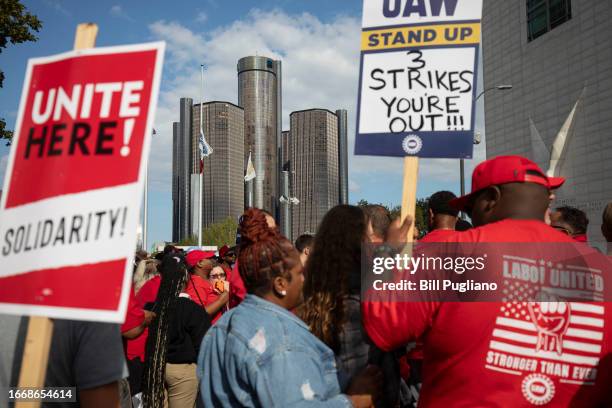With the General Motors world headquarters in the background, United Auto Workers members attend a solidarity rally as the UAW strikes the Big Three...