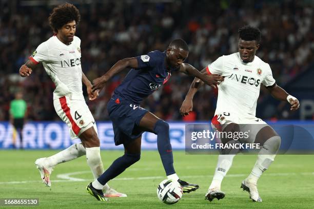 Paris Saint-Germain's French forward Randal Kolo Muani fights for the ball with Nice's Brazilian defender Dante and Nice's Burundian defender...