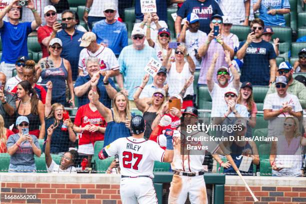 Matt Olson of the Atlanta Braves congratulates Austin Riley after hitting a home run during the game against the Los Angeles Angels at Truist Park on...