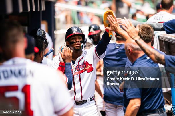Ronald Acuna Jr. #13 of the Atlanta Braves is congratulated by teammates after he scored during the game against the Los Angeles Angels at Truist...