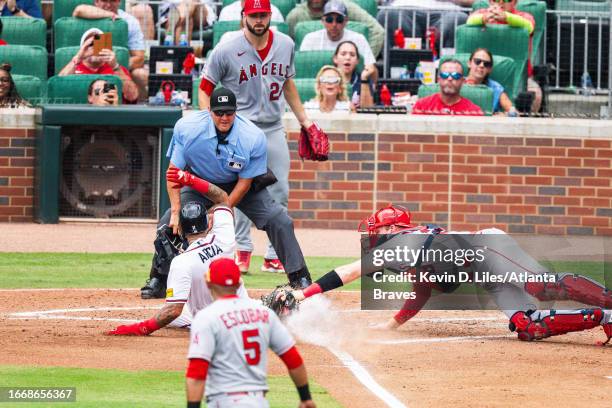 Orlando Arcia of the Atlanta Braves slides safely into home past Chad Wallach of the Los Angeles Angels during the game at Truist Park on August 02,...