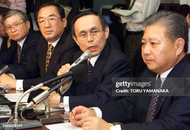 Ikuo Uno , president of Nippon Life InsuranceCo., answers questions from reporters during a press conference while Takeo Inokuchi , president of...