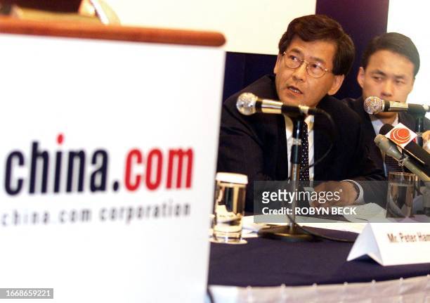The chief executive officer of china.com Corp, Peter Yip , is flanked by David Kim , chief financial officer, as he announces second quarter results,...