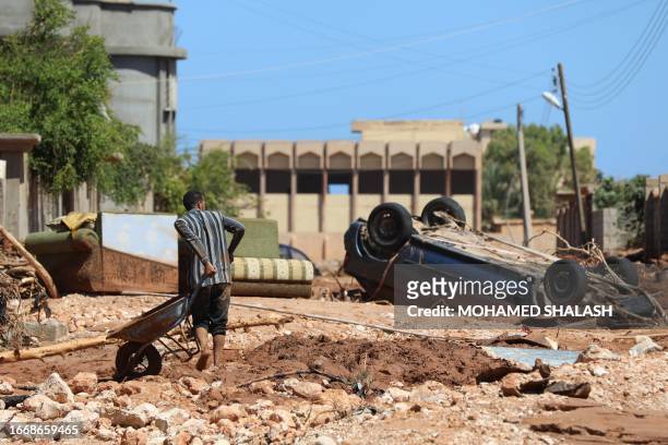 Man crosses the rubble filled street in Libya's eastern city of Soussa on September 15 after the Mediterranean storm "Daniel". Rescuers sifted...