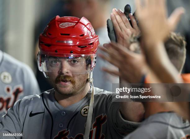 Detroit Tigers catcher Jake Rogers in the dugout wearing a Detroit Redwings hockey helmet after hitting a solo home run in the sixth inning of an MLB...