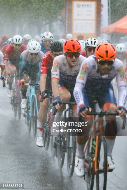 Cyclists celebrate with champagne on the podium during the 2023 11th Round Taihu International Road Cycling Race in Dianshanhu town, Kunshan city,...