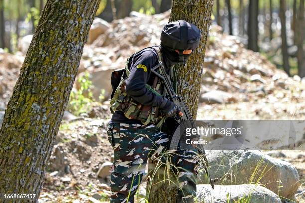 An Indian army soldier stands guard at Gadole forest of Kokernag in south Kashmir's Anantnag district on September 16, 2023. Five Indian officers and...