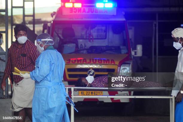 Health worker wearing protective gear shifts a woman with symptoms of Nipah virus to an isolation ward at a government hospital in Kozhikode in south...