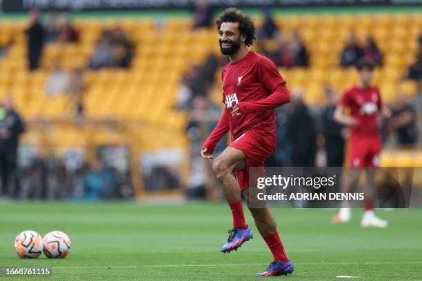 Liverpool's Egyptian striker Mohamed Salah smiles as he warms up ahead of the English Premier League football match between Wolverhampton Wanderers...