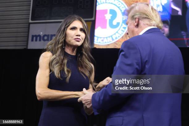 Republican presidential candidate former President Donald Trump greets South Dakota Governor Kristi Noem after she introduced him at the Monument...