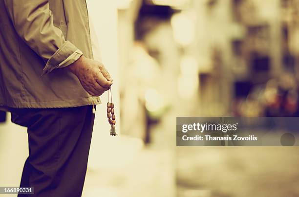 old man playing with his rosary - greek worry beads stock pictures, royalty-free photos & images