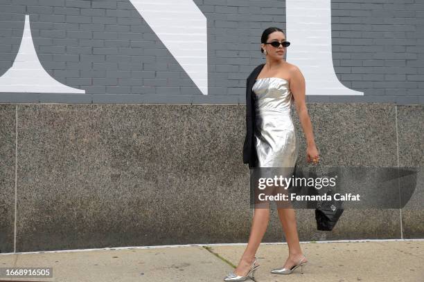 Adriana Brito wears Vicidolls silver dress, Calvin Klein jacket and Franco Sarto shoes outside Spring Studios during New York Fashion Week: The Shows...