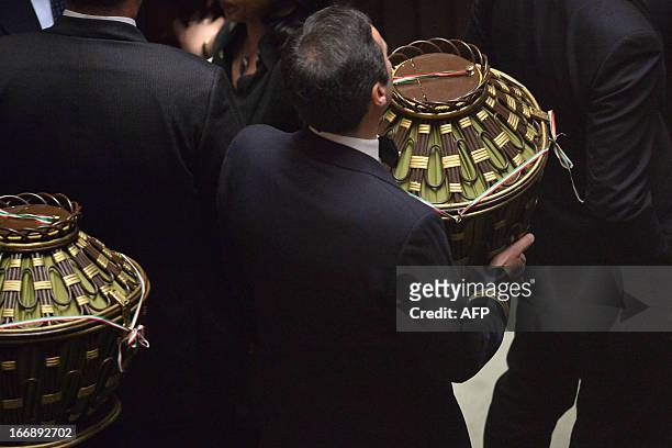 Assistants carry the urns after a vote during the election of the President of Italy on April 18, 2013 at the Italian parliament in Rome. While the...
