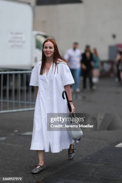 Guest seen outside Collina Strada show wearing silver necklace, white maxi dress, silver handbag and silver studed Alaia ballet flats on September...