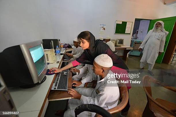 Teacher shows how to use computer at Madrasa, Taleem ul Quran at RK Puram in New Delhi.