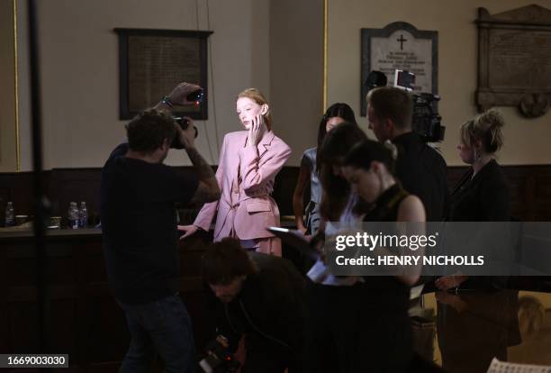 Models pose for pictures and have their final preparations made backstage ahead of the catwalk presentation for South Korean designer Eudon Choi's...