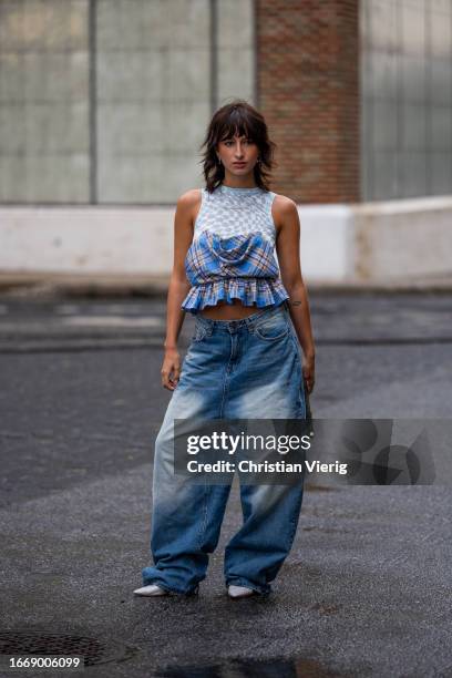 Guest wears wide denim jeans, top outside Collina Strada on September 08, 2023 in New York City.