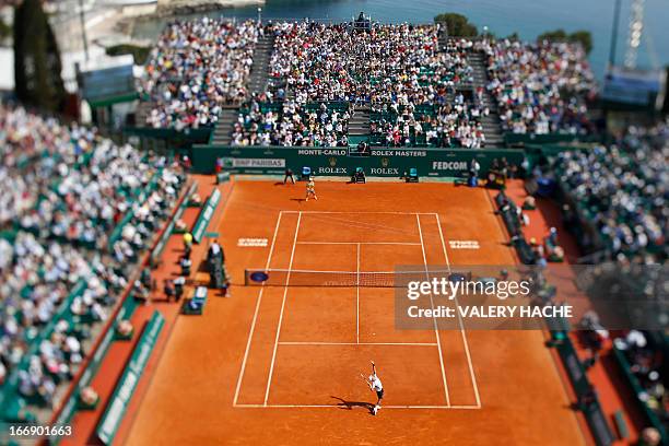 This picture taken with a tilt and shift lens shows Serbia's Novak Djokovic serving to Argentina's Juan Monaco during their Monte-Carlo ATP Masters...