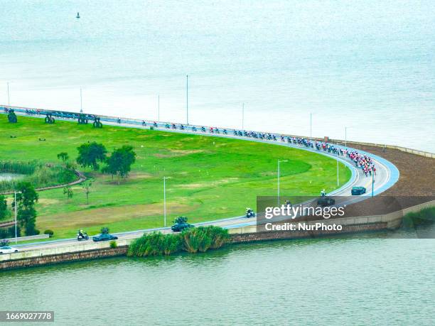 Cyclists celebrate with champagne on the podium during the 2023 11th Round Taihu International Road Cycling Race in Dianshanhu town, Kunshan city,...