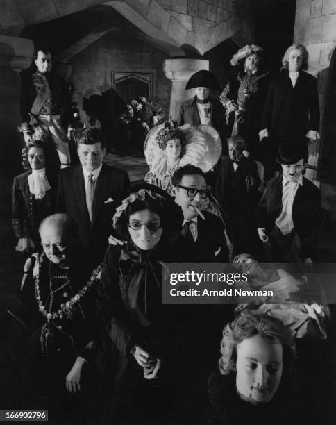 Portrait of American photographer Arnold Newman as he poses, cigar in mouth, with exhibits at Madame Tussauds wax museum, London, England, 1961.