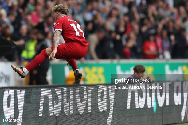 Liverpool's English midfielder Harvey Elliott jumps the advertising boards to celebrate with fans after his deflected shot makes it 3-1 during the...