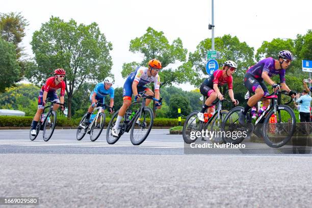 Cyclists celebrate with champagne on the podium during the 2023 11th Round Taihu International Road Cycling Race in Dianshanhu town, Kunshan city,...