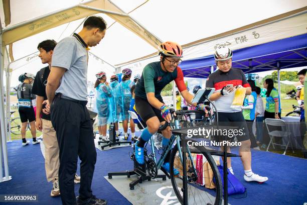 Cyclists celebrate with champagne on the podium during the 2023 11th Round Taihu International Road Cycling Race in Dianshanhu town, Kunshan city,...