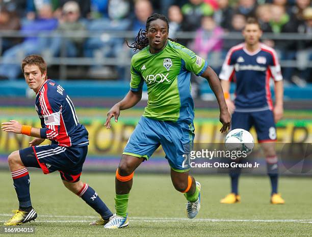 Shalrie Joseph of the Seattle Sounders FC dribbles against Kelyn Rowe of the New England Revolution at CenturyLink Field on April 13, 2013 in...