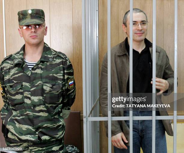 The imprisoned former head of Yukos oil company, Mikhail Khodorkovsky, stands in the defendant's box during his trial in the court in Moscow, 31...