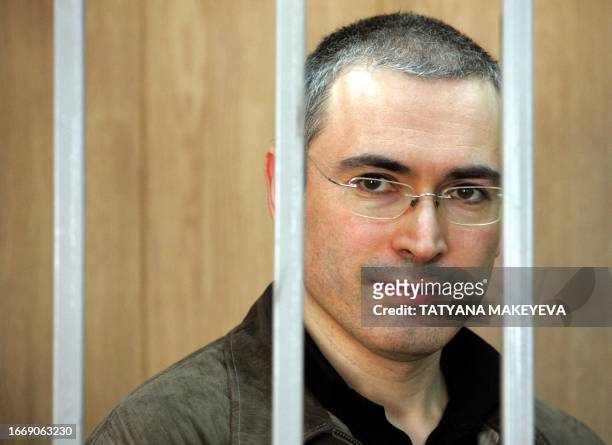 The imprisoned former head of Yukos oil company, Mikhail Khodorkovsky, stands in the defendant's box during his trial in the court in Moscow, 31...