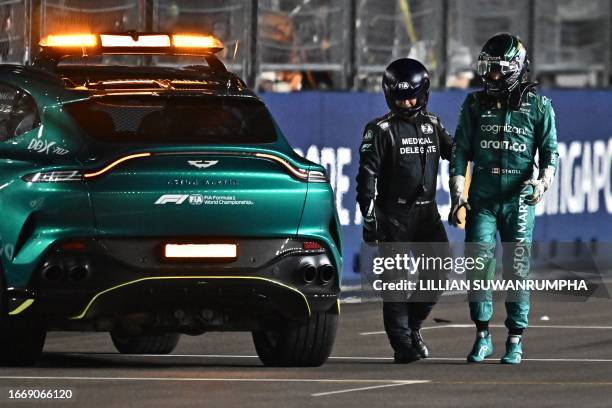 Aston Martin's Canadian driver Lance Stroll walks away after crashing his car during the qualifying session of the Singapore Formula One Grand Prix...